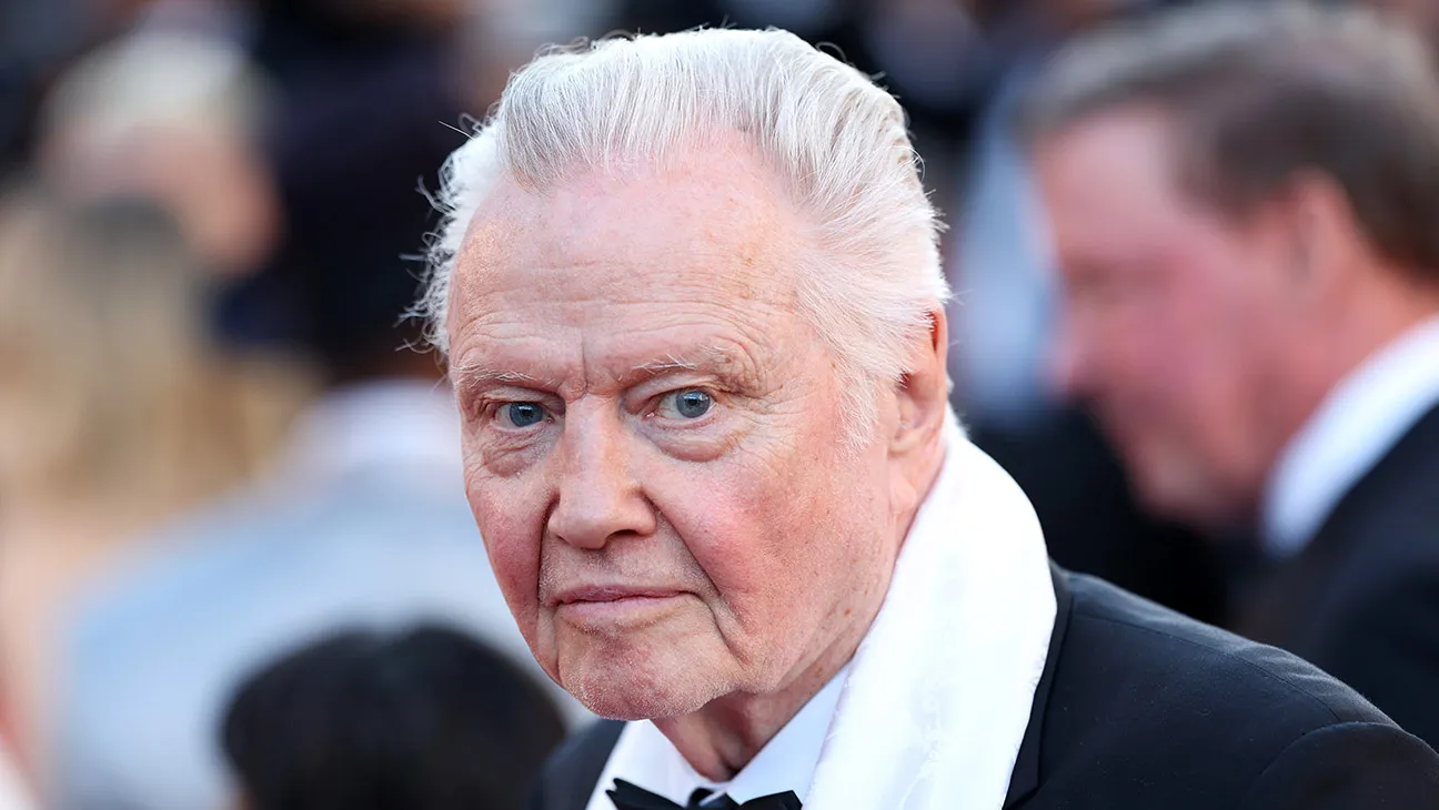 Jon Voight speaking on stage at a press conference